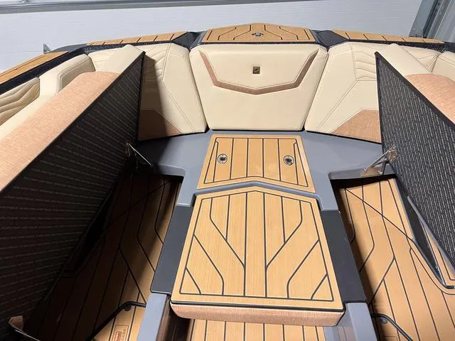 Slide: The Image of 2025 Nautique Super Air Nautique G23 boat interior with teak flooring and beige seating. - 33