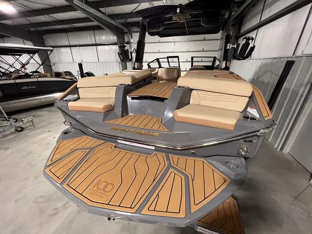Slide: The Image of 2025 Nautique Super Air Nautique G23 boat with teak deck in a storage facility. - 7