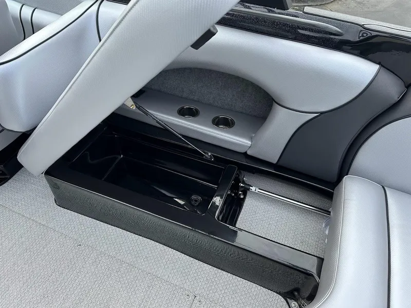 Slide: The Image of 2024 Sanger V237 SX boat interior with open storage compartment and cup holders. - 16