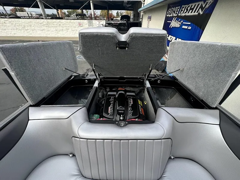 Slide: The Image of 2024 Sanger V237 SX boat engine compartment with open hatches, showcasing interior design. - 26