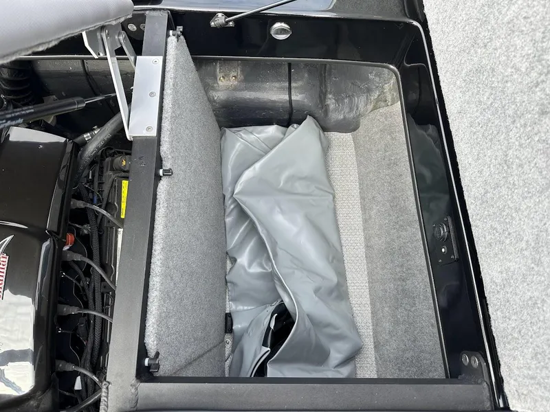 Slide: The Image of 2024 Sanger V237 SX boat storage compartment with gray interior and engine components. - 29