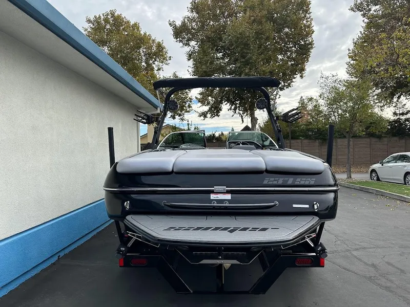 Slide: The Image of 2024 Sanger V237 SX boat, rear view, parked outdoors. - 5