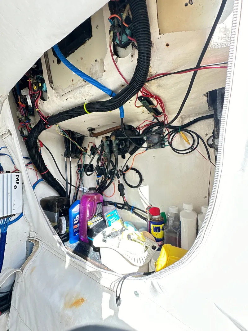 Slide: The Image of Electrical wiring and maintenance supplies inside a 1988 Ocean Master 31 Center Console boat. - 31