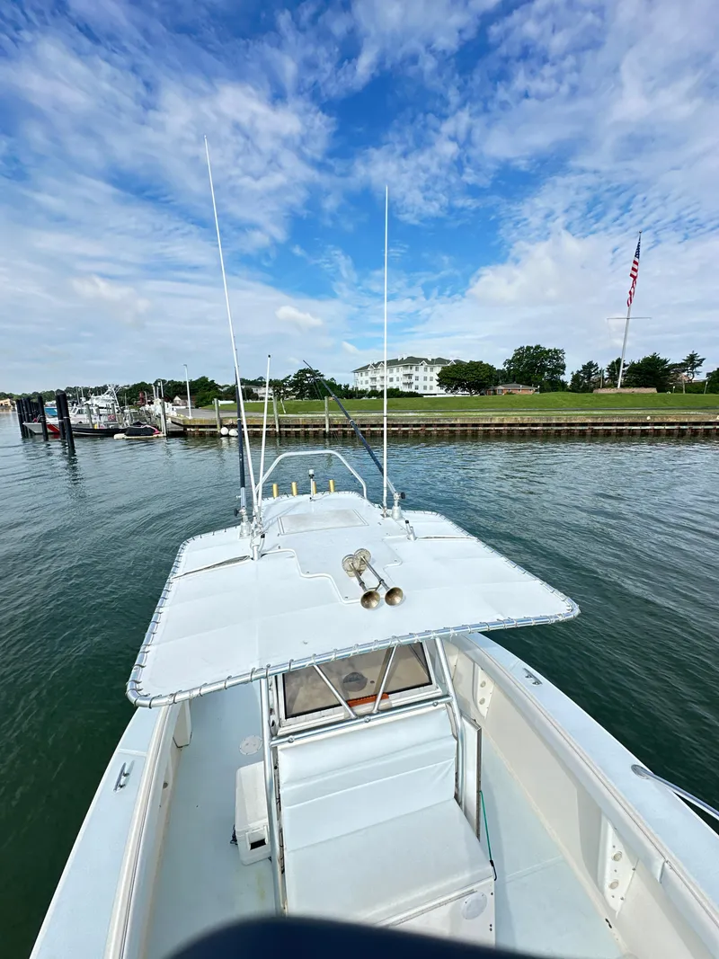 Slide: The Image of 1988 Ocean Master 31 Center Console boat docked in a marina with a clear sky. - 20
