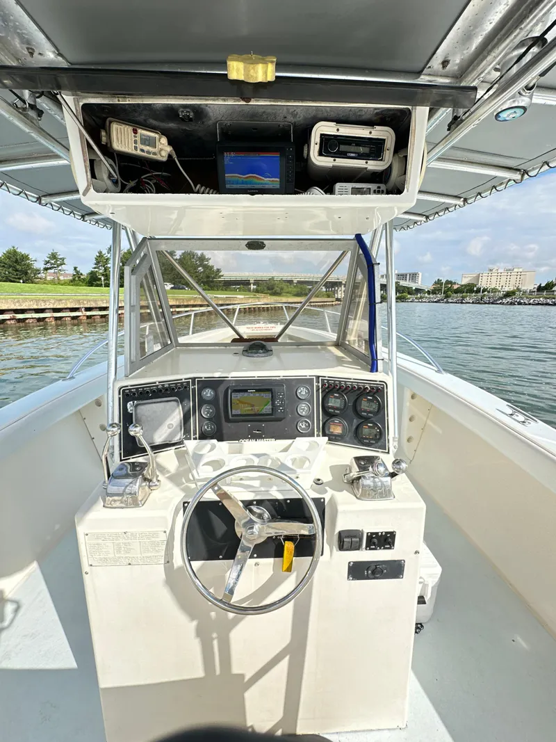 Slide: The Image of 1988 Ocean Master 31 Center Console boat dashboard with steering wheel and navigation equipment. - 13