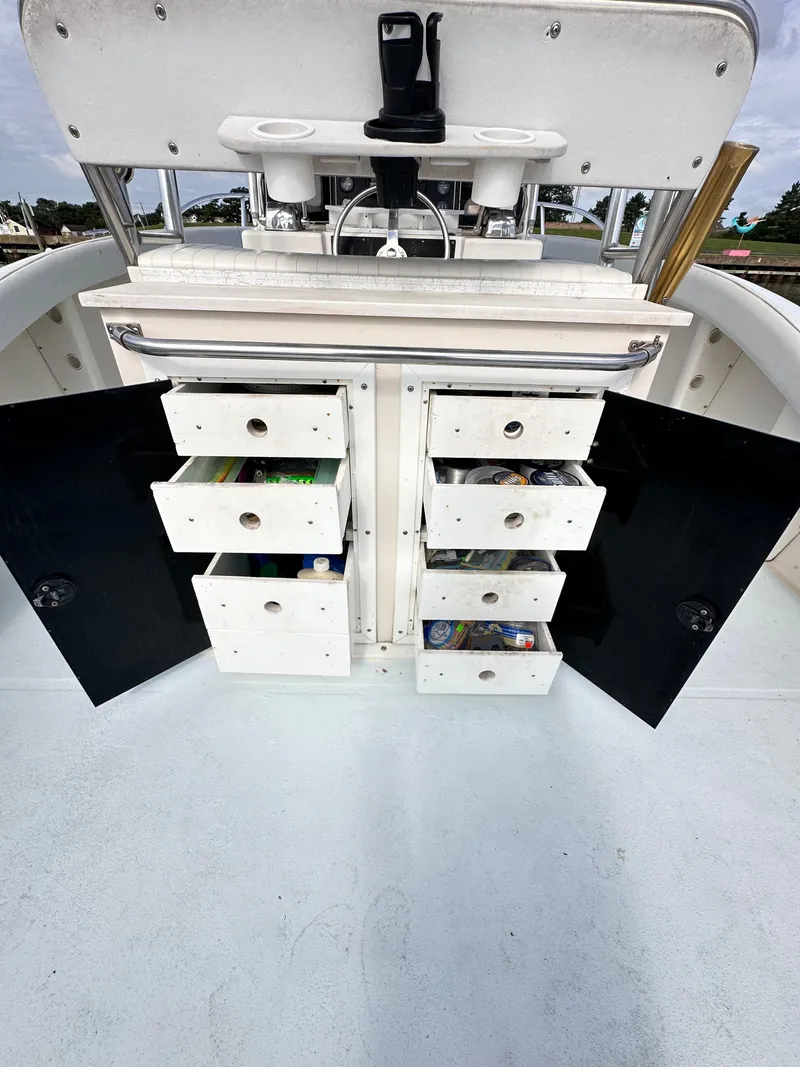Slide: The Image of 1988 Ocean Master 31 Center Console with open storage drawers and compartments. - 24
