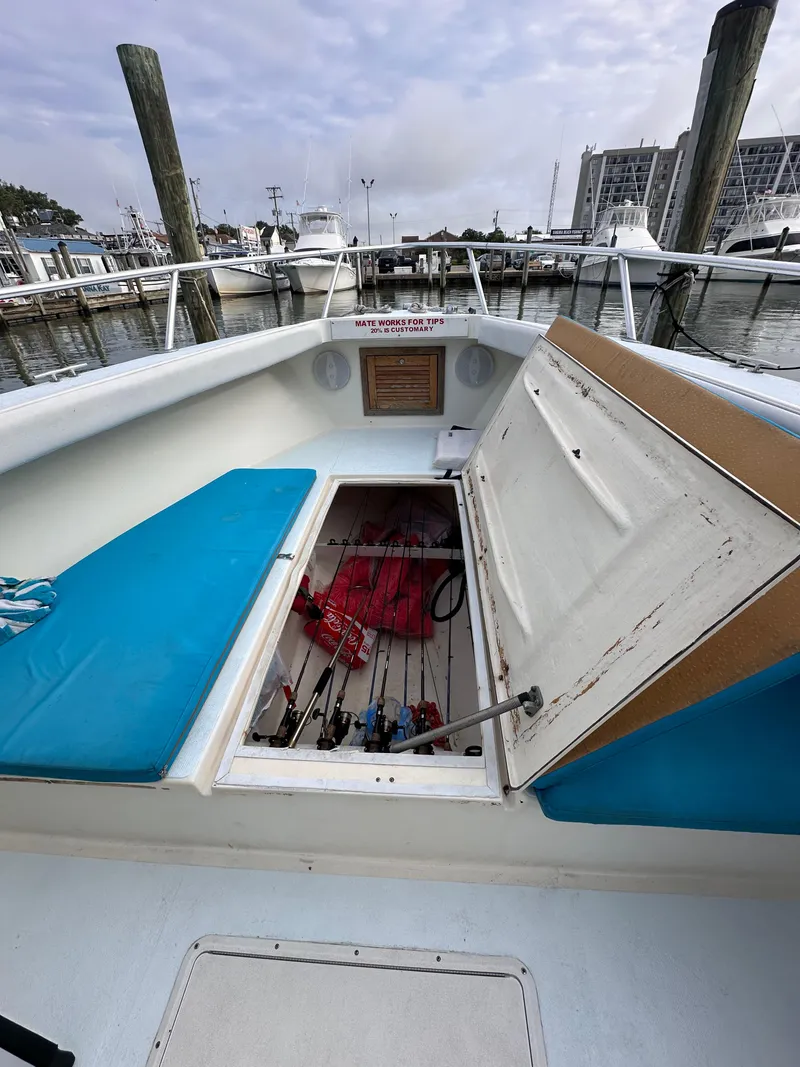 Slide: The Image of 1988 Ocean Master 31 Center Console boat with open storage compartment at marina. - 15