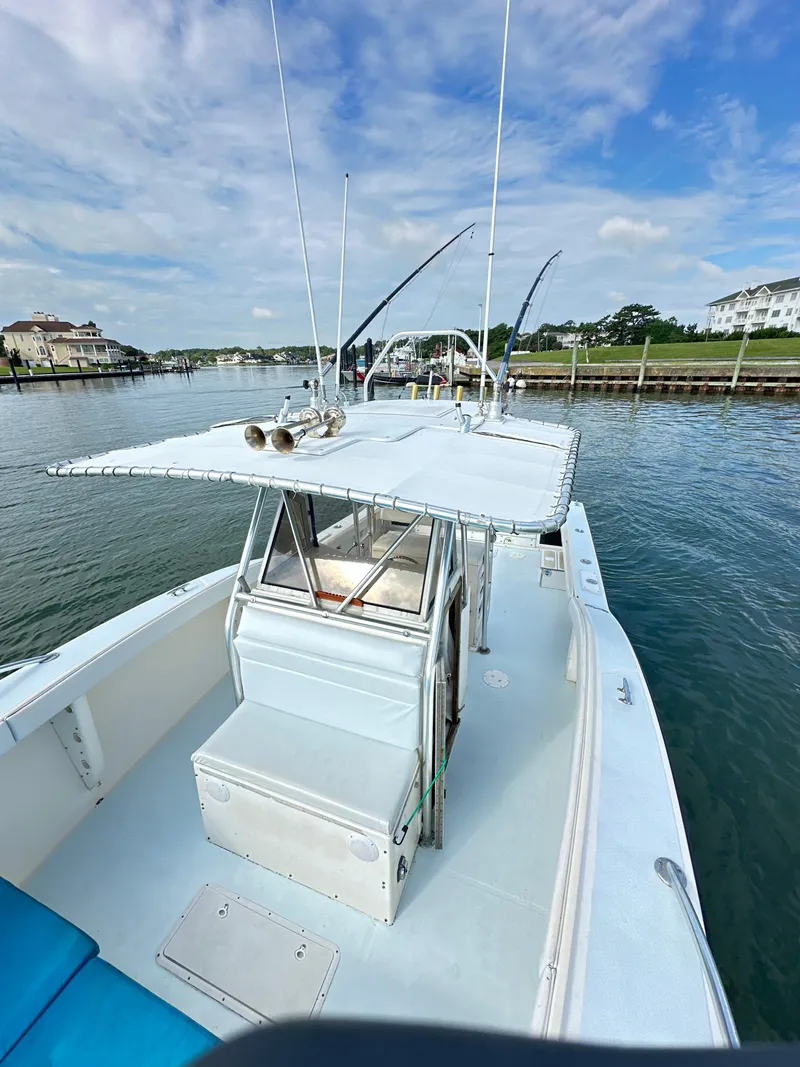 Slide: The Image of 1988 Ocean Master 31 Center Console boat docked by waterfront homes. - 18