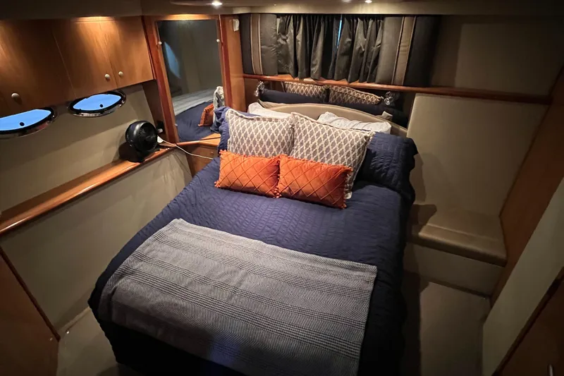 Slide: The Image of 2008 Cruisers 395 Motoryacht bedroom with cozy bedding, wood cabinets, and ambient lighting. - 28