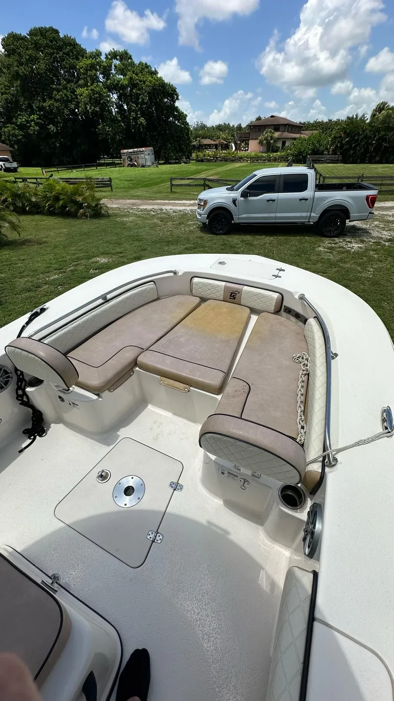 Slide: The Image of 2023 Carolina Skiff 24 Ultra Elite boat with spacious seating and a white pickup truck in the background. - 10