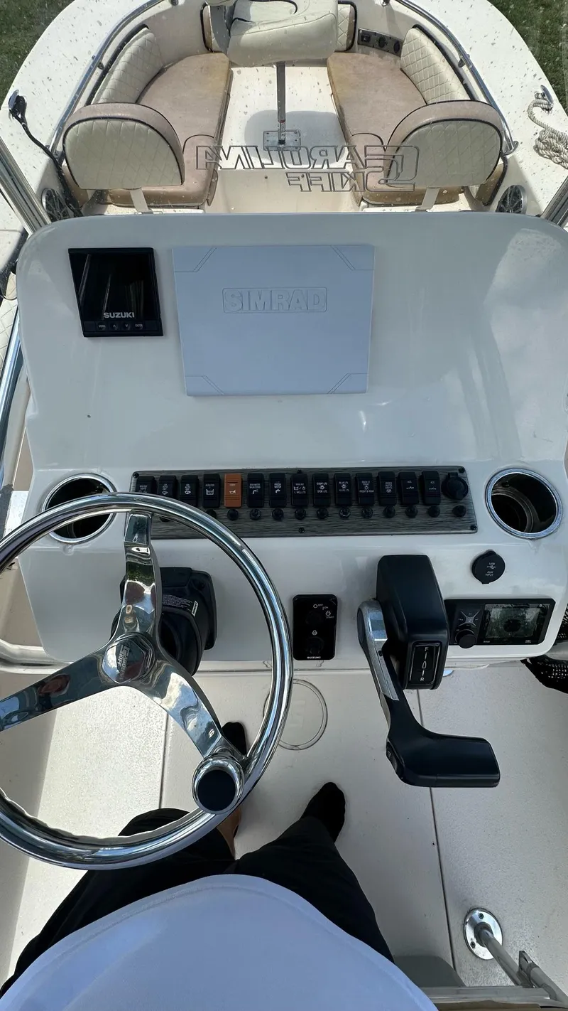 Slide: The Image of 2023 Carolina Skiff 24 Ultra Elite boat console with steering wheel and controls. - 19