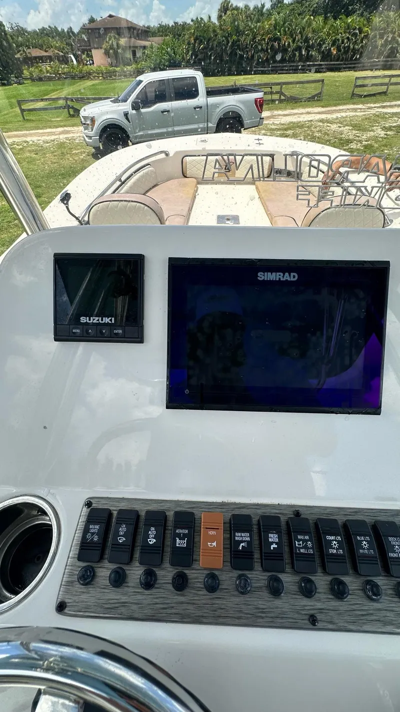 Slide: The Image of Control panel of a 2023 Carolina Skiff 24 Ultra Elite boat with Simrad and Suzuki displays. - 21