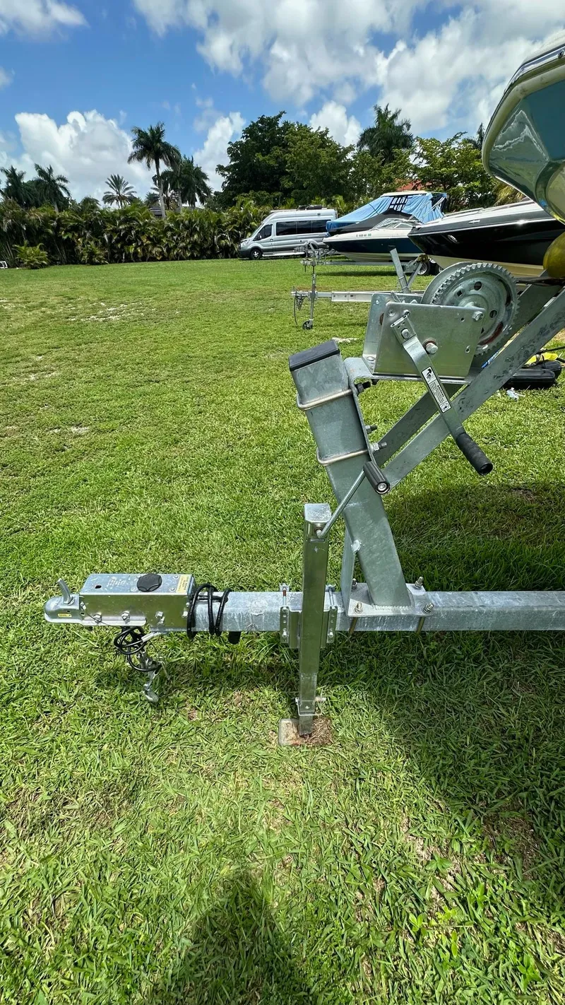 Slide: The Image of 2023 Carolina Skiff 24 Ultra Elite boat trailer on grassy field. - 37