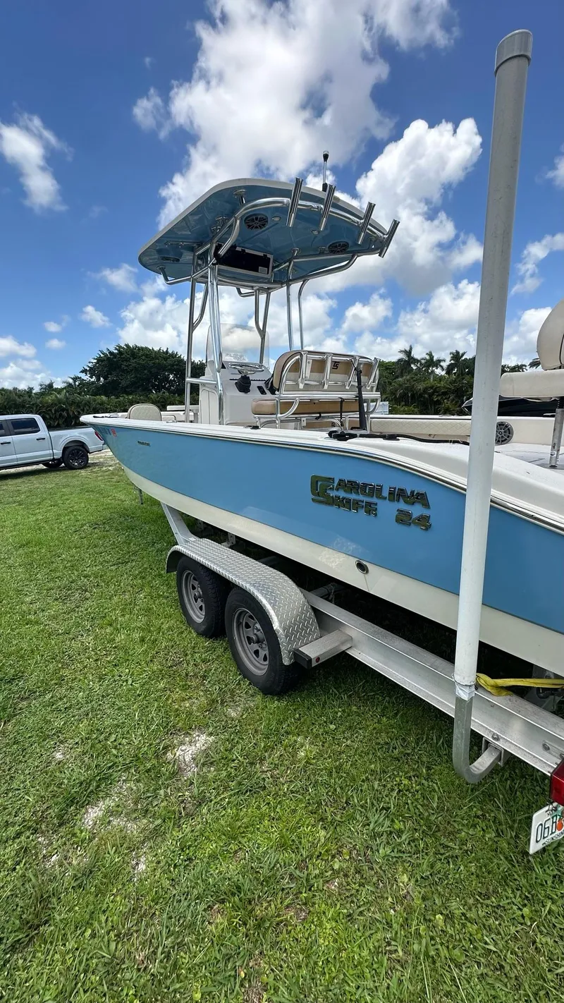 Slide: The Image of 2023 Carolina Skiff 24 Ultra Elite boat on trailer, blue hull, parked on grass. - 5