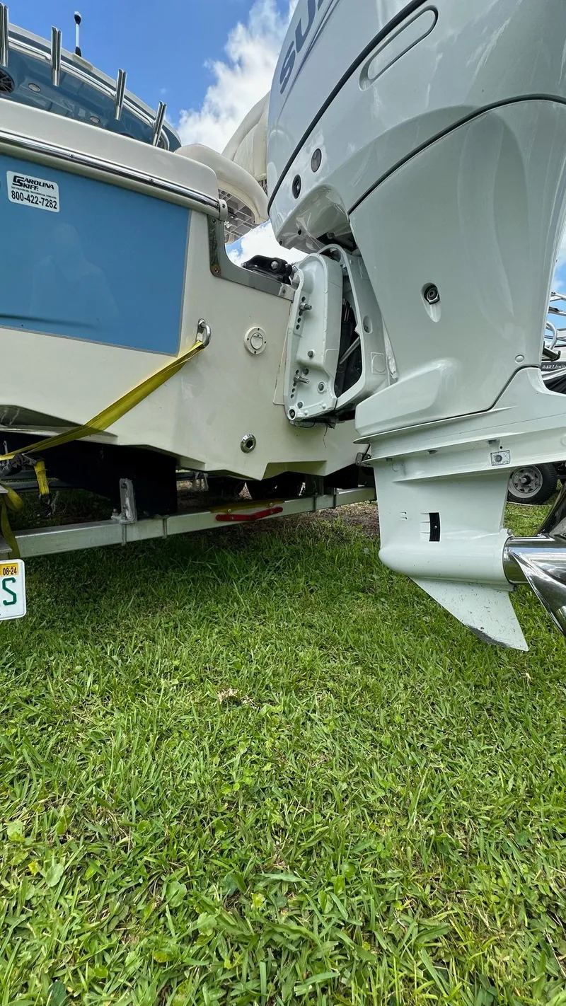 Slide: The Image of 2023 Carolina Skiff 24 Ultra Elite boat on trailer, close-up of outboard motor and hull. - 8