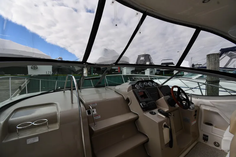 Slide: The Image of 2009 Sea Ray 330 Sundancer cockpit with steering wheel, dashboard, and clear canopy view. - 10