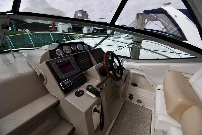 Slide: The Image of 2009 Sea Ray 330 Sundancer helm with steering wheel, gauges, and navigation equipment. - 11