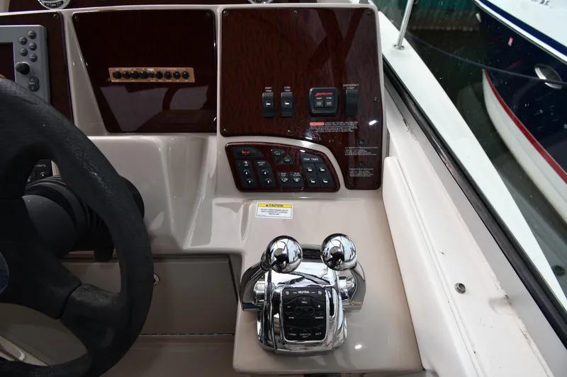Slide: The Image of Control panel of a 2009 Sea Ray 330 Sundancer boat with steering wheel and throttle levers. - 13