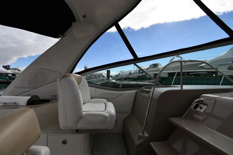 Slide: The Image of Interior view of 2009 Sea Ray 330 Sundancer yacht with white seating and large windows. - 15