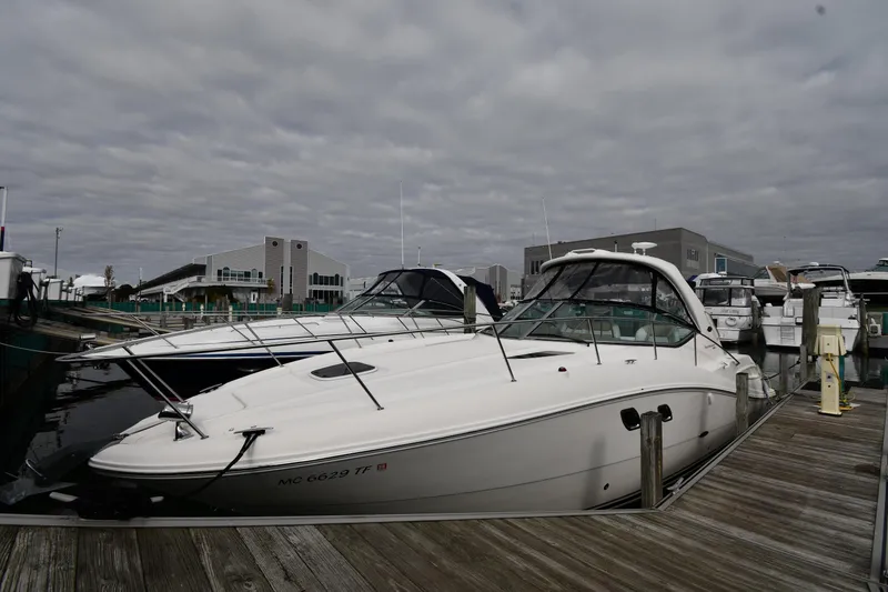 The Image of 2009 Sea Ray 330 Sundancer docked at marina under cloudy sky. - 2