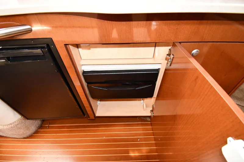 Slide: The Image of 2009 Sea Ray 330 Sundancer interior with wooden cabinetry and compact refrigerator. - 37
