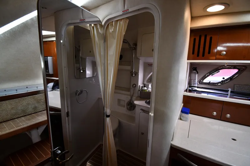 Slide: The Image of Interior of 2009 Sea Ray 330 Sundancer, featuring a compact bathroom and kitchenette. - 38
