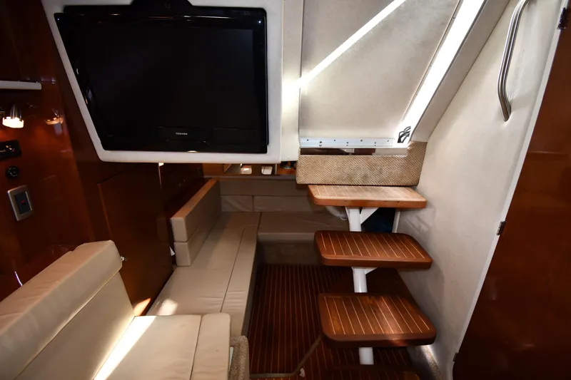 Slide: The Image of Interior of 2009 Sea Ray 330 Sundancer with TV, seating, and wooden steps. - 39