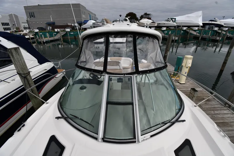 Slide: The Image of 2009 Sea Ray 330 Sundancer docked at marina, showcasing sleek design and spacious cockpit. - 8
