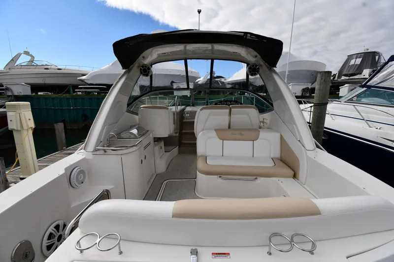 Slide: The Image of 2009 Sea Ray 330 Sundancer boat interior with seating and helm, docked at marina. - 9