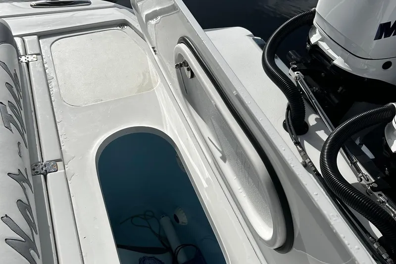 Slide: The Image of 2021 Nor-Tech 390 Sport Center Console boat interior with storage compartments and Mercury engine. - 12