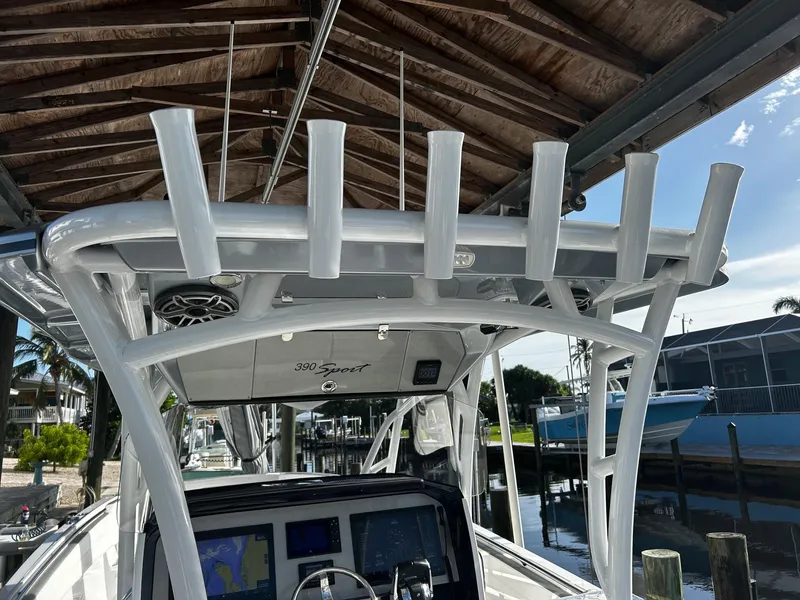 Slide: The Image of 2021 Nor-Tech 390 Sport Center Console boat docked under a wooden canopy. - 16