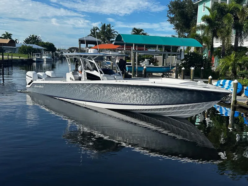 Slide: The Image of 2021 Nor-Tech 390 Sport Center Console boat docked in a scenic canal. - 2