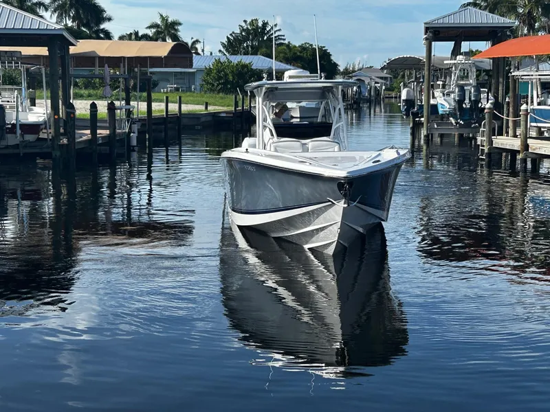 Slide: The Image of 2021 Nor-Tech 390 Sport Center Console boat cruising in a calm marina. - 3