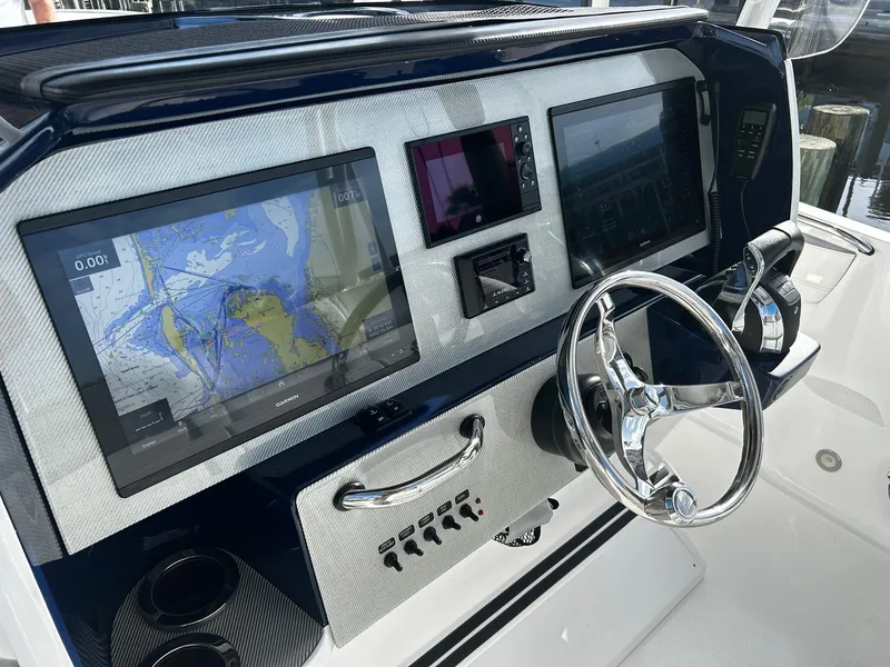 Slide: The Image of 2021 Nor-Tech 390 Sport Center Console dashboard with navigation screens and steering wheel. - 7