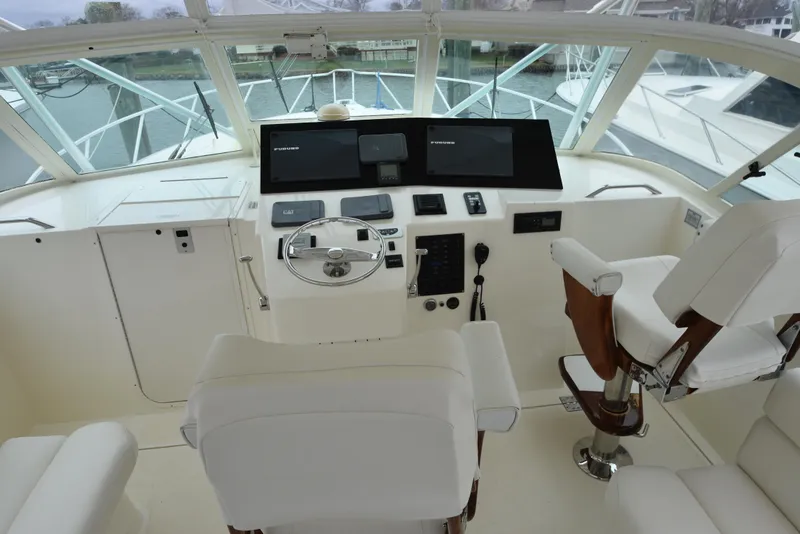 Slide: The Image of 2006 Albemarle 41 Express helm station with modern navigation equipment and white captain's chairs. - 11