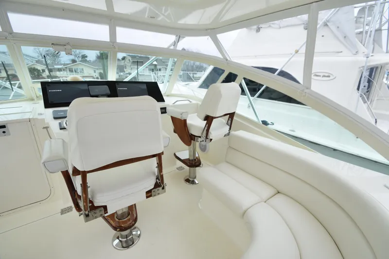 Slide: The Image of Interior helm of 2006 Albemarle 41 Express yacht with white seating and modern controls. - 12