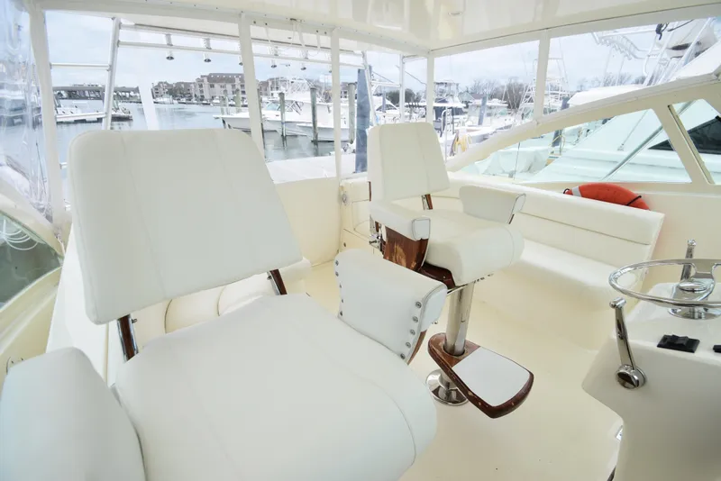 Slide: The Image of Interior of 2006 Albemarle 41 Express yacht with white seating and marina view. - 16