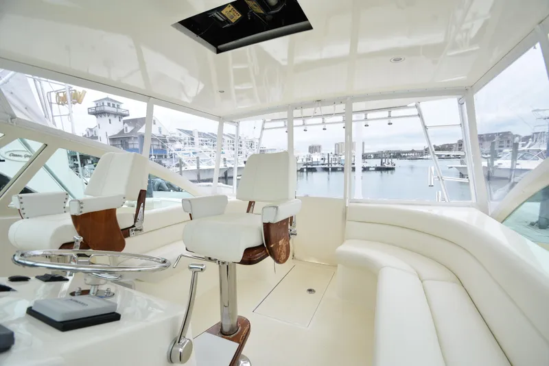 Slide: The Image of Interior of 2006 Albemarle 41 Express yacht with white seating and marina view. - 18