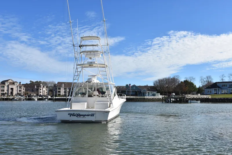 Slide: The Image of 2006 Albemarle 41 Express boat cruising near waterfront homes. - 8