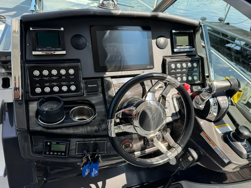 Slide: The Image of Control panel of a 2019 Monterey 335 SY boat with steering wheel and navigation equipment. - 11