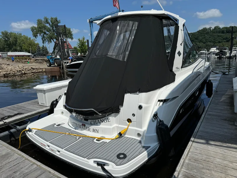 Slide: The Image of 2019 Monterey 335 SY boat docked at a marina, rear view with black cover. - 2