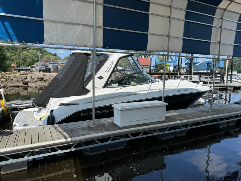 Slide: The Image of 2019 Monterey 335 SY boat docked under a canopy at a marina. - 29