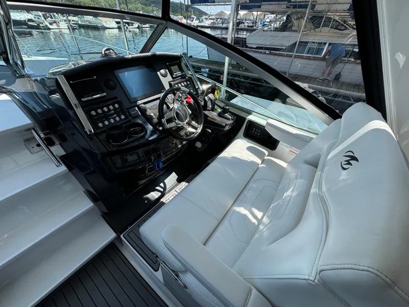 Slide: The Image of Cockpit of 2019 Monterey 335 SY boat with modern controls and white seating. - 9