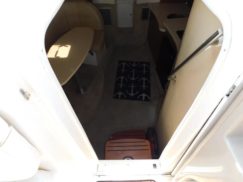 Slide: The Image of Interior cabin of a 2002 Rinker 310 Fiesta Vee boat with seating and anchor-themed rug. - 32
