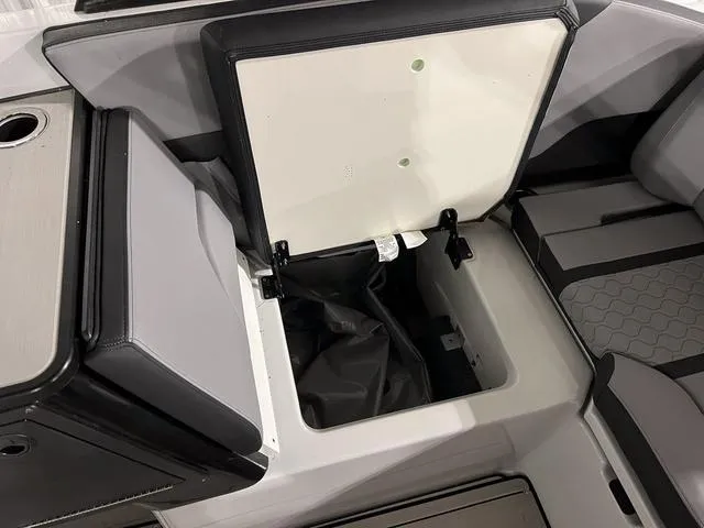 Slide: The Image of 2024 Yamaha Boats 255XE storage compartment with open lid, showcasing interior space. - 12