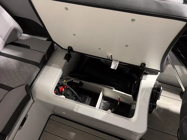 Slide: The Image of 2024 Yamaha Boats 255XE storage compartment with open lid, showcasing interior details. - 13