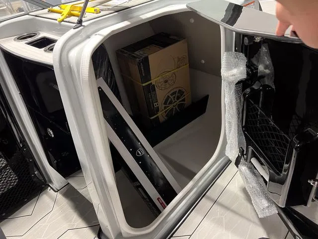 Slide: The Image of 2024 Yamaha Boats 255XE storage compartment with accessories and packaging inside. - 17