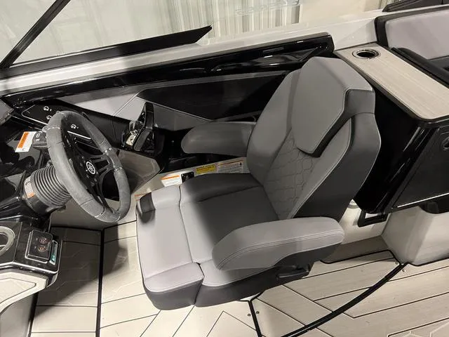 Slide: The Image of 2024 Yamaha Boats 255XE cockpit with sleek steering wheel and comfortable seating. - 18