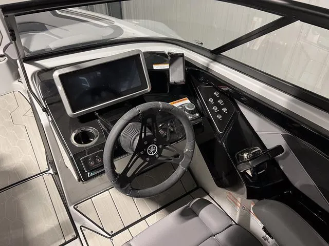 Slide: The Image of 2024 Yamaha Boats 255XE cockpit with modern steering and touchscreen display. - 19