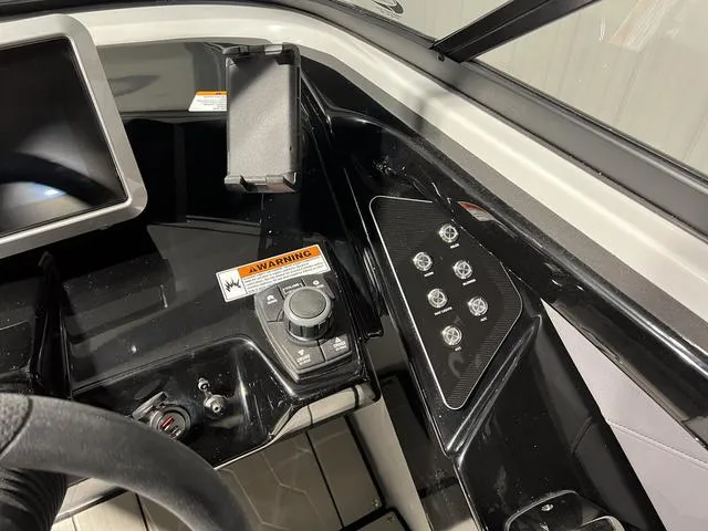 Slide: The Image of 2024 Yamaha Boats 255XE dashboard with control panel and warning label. - 22